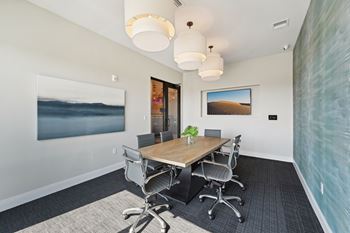 A conference room with a long table and chairs.